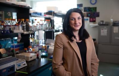 A woman stands in a medical research lab.